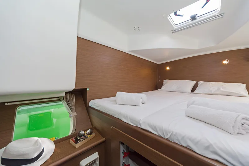  Yacht Photos Pics Luxurious cabin interior of 2017 Lagoon 380 S2 catamaran with double bed and porthole view.