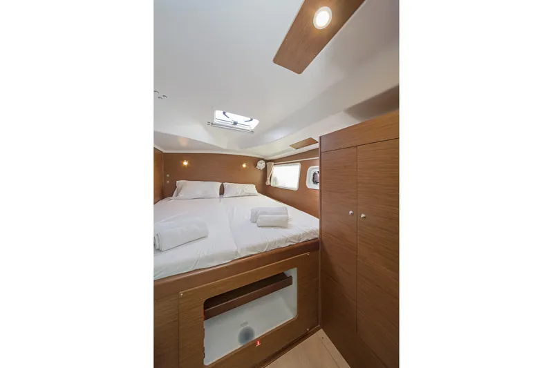  Yacht Photos Pics Interior cabin of 2017 Lagoon 380 S2 catamaran with cozy bed and wooden finish.