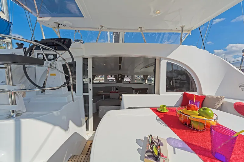  Yacht Photos Pics 2017 Lagoon 380 S2 catamaran cockpit with fruit basket, helm, and seating area.