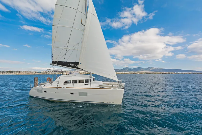  Yacht Photos Pics Sailing catamaran Lagoon 380 S2, 2017 model, cruising on open sea under blue sky.