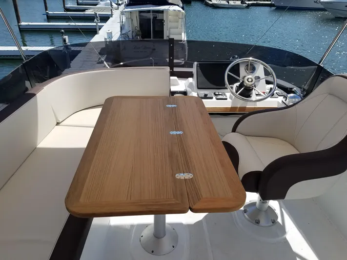  Yacht Photos Pics Flybridge seating area on 2019 Beneteau Swift Trawler 35 with table and helm.