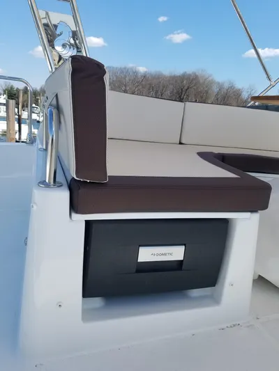  Yacht Photos Pics 2019 Beneteau Swift Trawler 35 seating area with storage compartment, under clear blue sky.