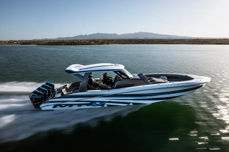  Yacht Photos Pics 2023 MTI V42 boat cruising on a calm lake with mountains in the background.