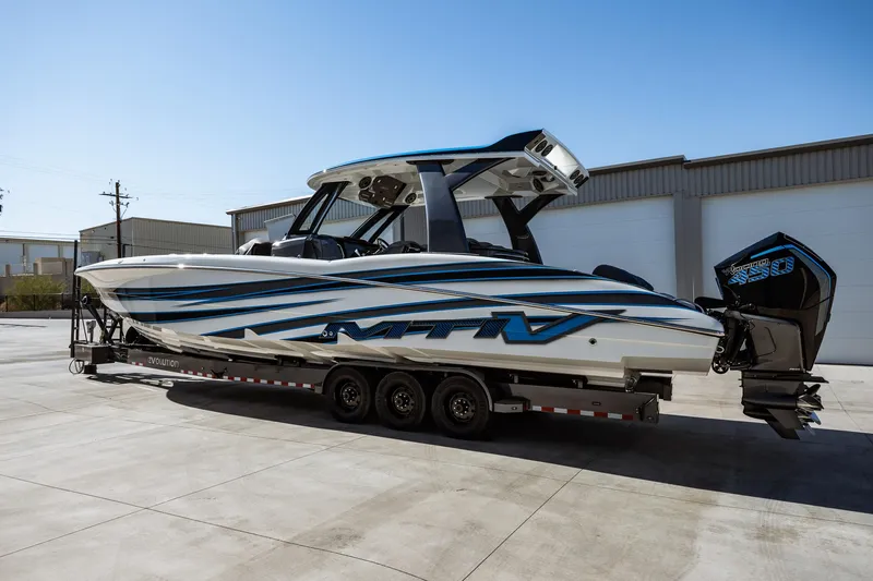  Yacht Photos Pics 2023 MTI V42 boat on a trailer, parked outside a warehouse.