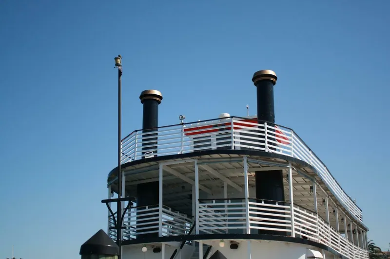 Indian River Queen Yacht Photos Pics Custom 1984 paddle wheel boat with dual smokestacks against clear blue sky.