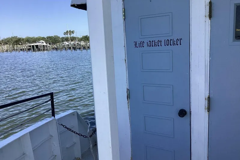 Indian River Queen Yacht Photos Pics Blue life jacket locker door on a 1984 Custom Paddle Wheel boat by the water.