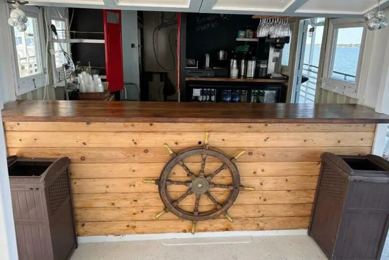 Indian River Queen Yacht Photos Pics Rustic bar with wooden ship wheel decor on a custom 1984 paddle wheel boat.