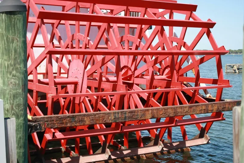 Indian River Queen Yacht Photos Pics Red custom paddle wheel from 1984 on a boat docked by the water.