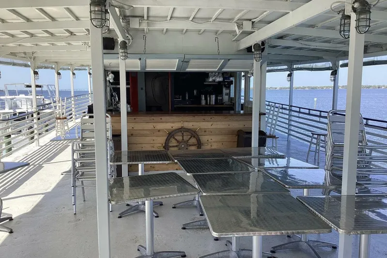 Indian River Queen Yacht Photos Pics Open deck of a 1984 custom paddle wheel boat with tables and a bar.