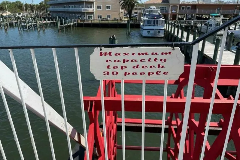 Indian River Queen Yacht Photos Pics Sign on a custom 1984 paddle wheel boat, "Maximum capacity top deck 30 people."