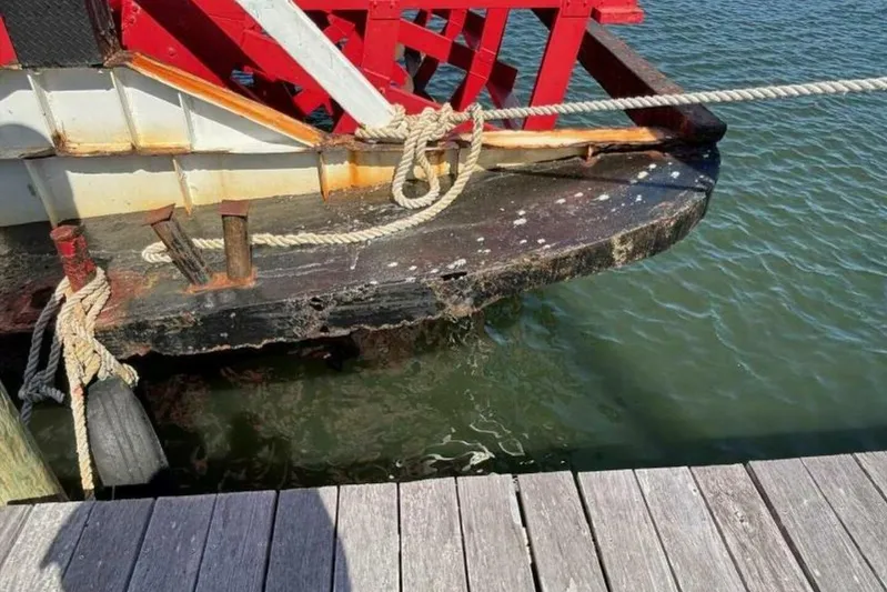 Indian River Queen Yacht Photos Pics Close-up of a 1984 custom paddle wheel boat docked, showing ropes and weathered wood.