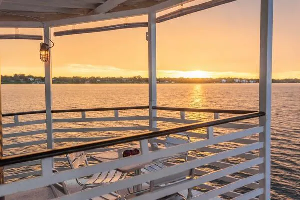 Indian River Queen Yacht Photos Pics Sunset view from a 1984 custom paddle wheel boat deck over tranquil water.