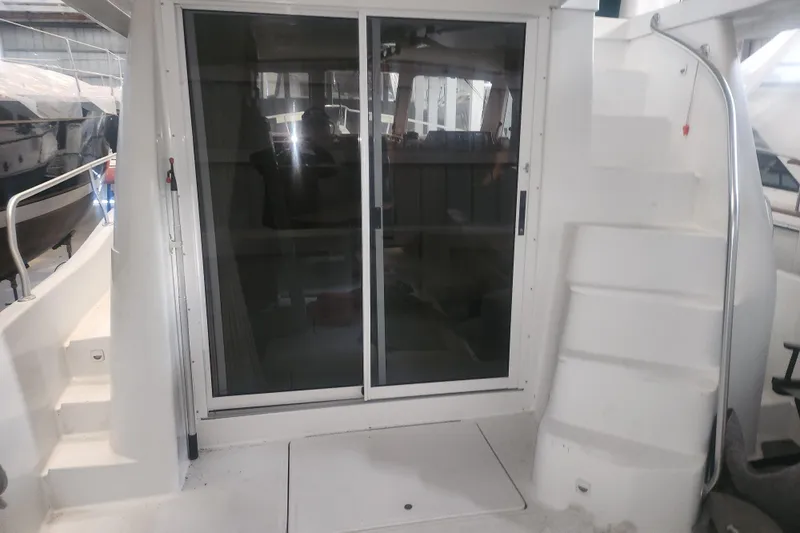 Teddy B Yacht Photos Pics 1997 Mainship 350 Trawler with sliding glass doors and exterior stairs in a marina setting.