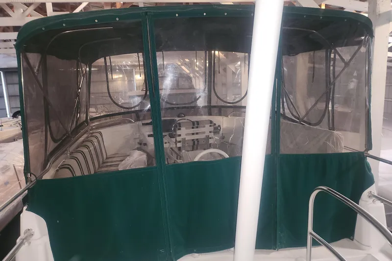 Teddy B Yacht Photos Pics 1997 Mainship 350 Trawler with green canopy, docked indoors.