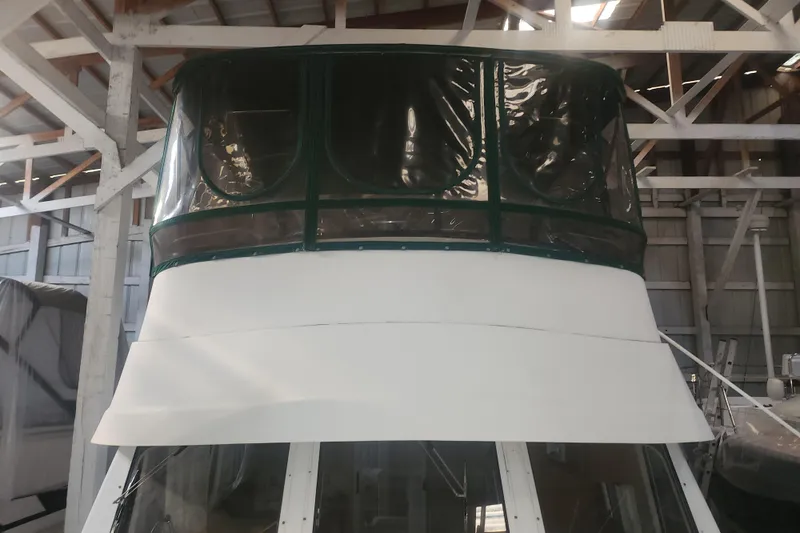 Teddy B Yacht Photos Pics 1997 Mainship 350 Trawler in storage, featuring enclosed flybridge and white exterior.