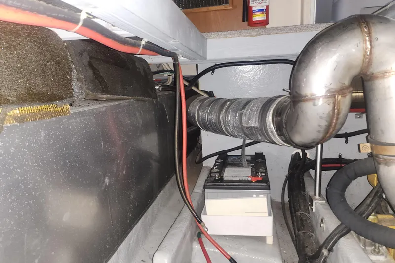 Teddy B Yacht Photos Pics Engine room of a 1997 Mainship 350 Trawler with visible battery and exhaust system.
