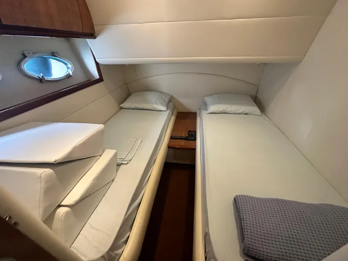  Yacht Photos Pics Twin cabin interior of 2000 Pershing 54 yacht, featuring two beds and a porthole.