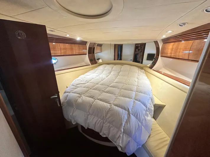  Yacht Photos Pics Luxurious bedroom interior of 2000 Pershing 54 yacht, featuring elegant wood finishes and cozy bedding.