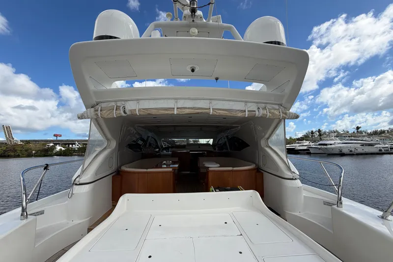  Yacht Photos Pics 2004 Mangusta 72 yacht docked, showcasing spacious deck and luxurious interior under a blue sky.