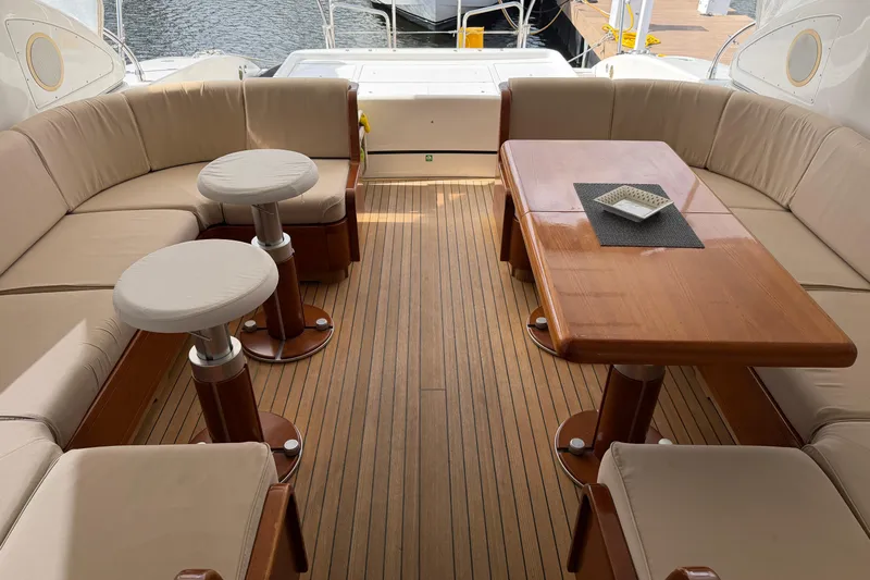  Yacht Photos Pics Luxurious 2004 Mangusta 72 yacht interior with elegant seating and wooden table.