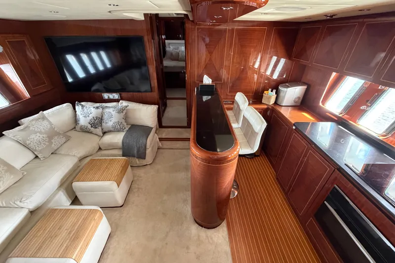  Yacht Photos Pics Luxurious interior of 2004 Mangusta 72 yacht with elegant wood finishes and plush seating.