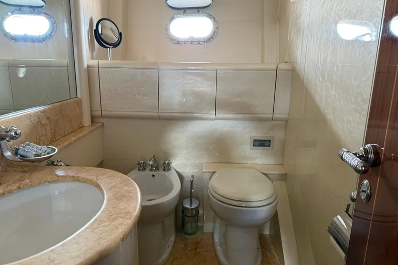  Yacht Photos Pics Luxurious bathroom in 2004 Mangusta 72 yacht with marble sink and porthole window.