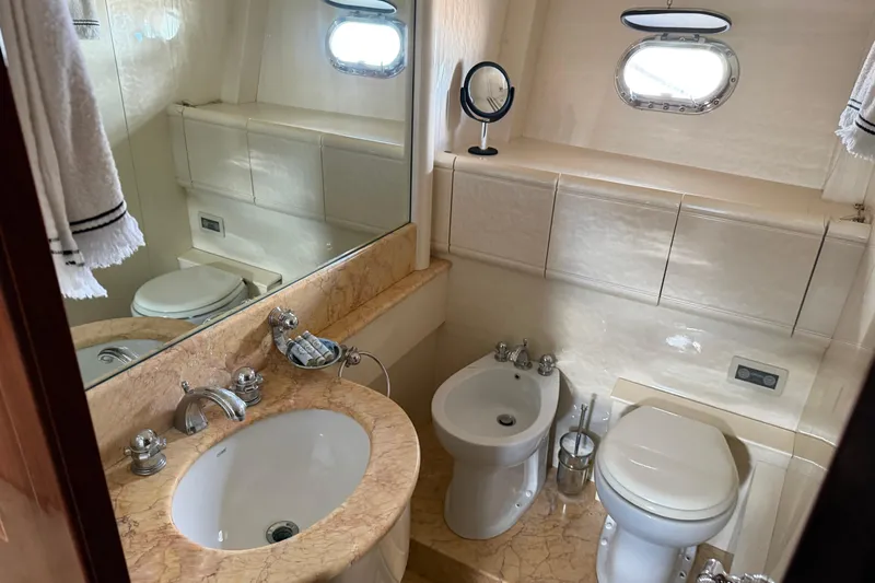  Yacht Photos Pics Luxurious bathroom in 2004 Mangusta 72 yacht with marble sink and modern fixtures.