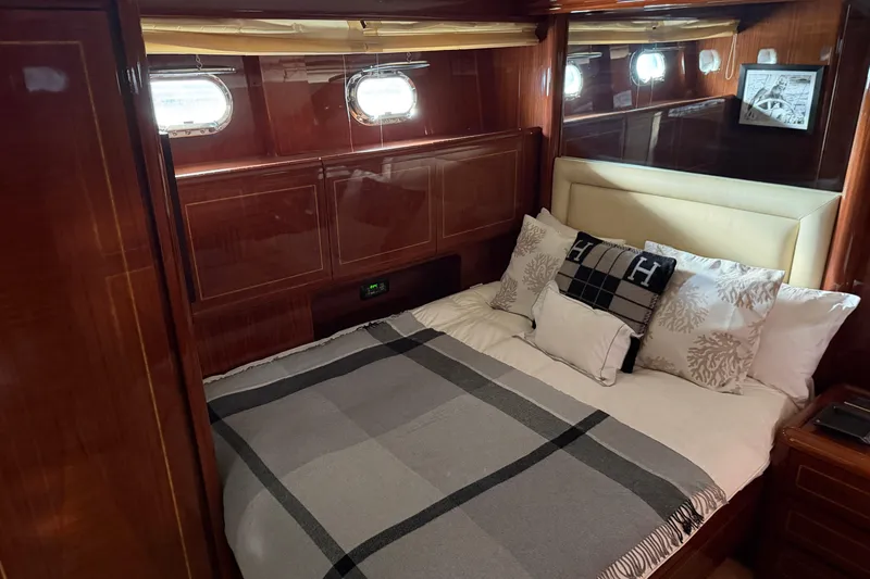  Yacht Photos Pics Luxurious cabin interior of 2004 Mangusta 72 yacht with elegant bedding and wood paneling.
