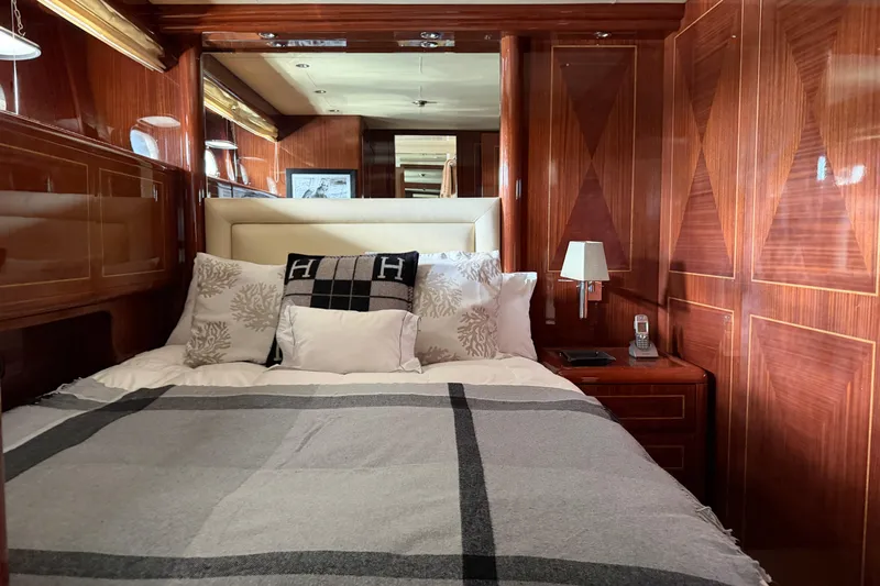  Yacht Photos Pics Luxurious 2004 Mangusta 72 yacht bedroom with elegant wood paneling and plush bedding.