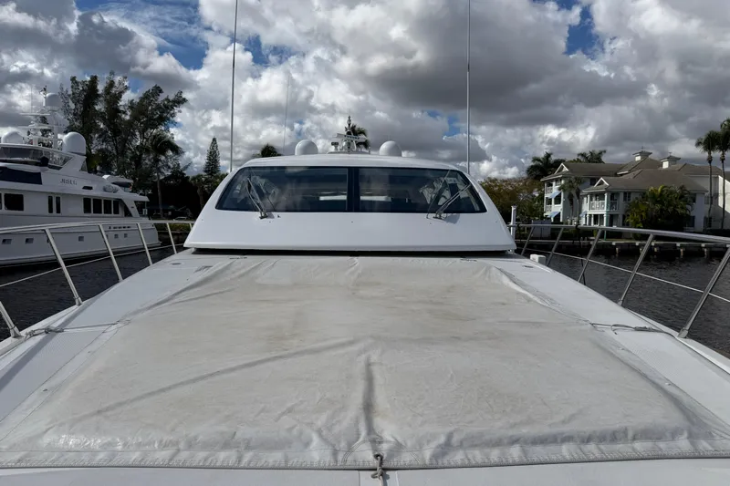  Yacht Photos Pics 2004 Mangusta 72 yacht docked under cloudy skies, showcasing sleek design and spacious deck.