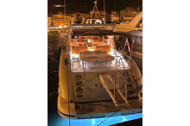  Yacht Photos Pics Luxurious 2004 Mangusta 72 yacht docked at night, illuminated with warm lights.