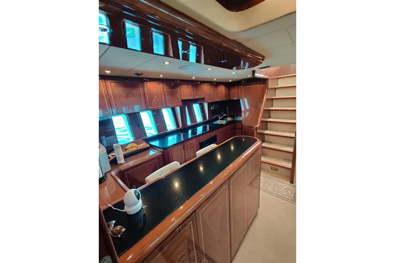  Yacht Photos Pics Luxurious 2004 Mangusta 72 yacht interior with elegant wood cabinetry and modern kitchen amenities.
