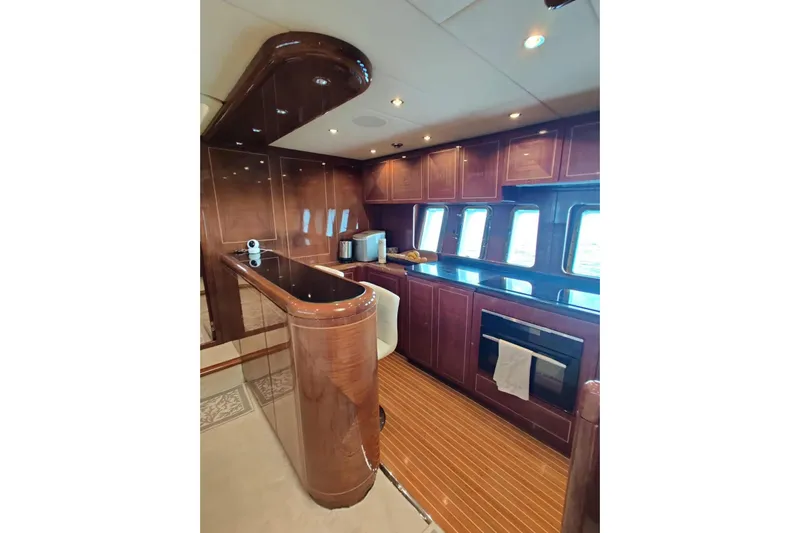  Yacht Photos Pics Luxurious kitchen interior of 2004 Mangusta 72 yacht with wood cabinetry and modern appliances.
