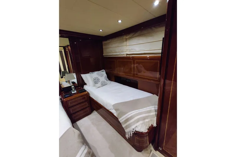  Yacht Photos Pics Luxurious cabin interior of 2004 Mangusta 72 yacht with elegant wood finish and cozy bedding.