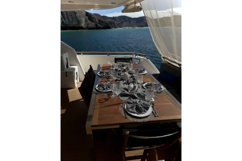 Big Blue Yacht Photos Pics Luxurious dining setup on 2014 Fairline Squadron 78 Custom yacht, overlooking serene waters.