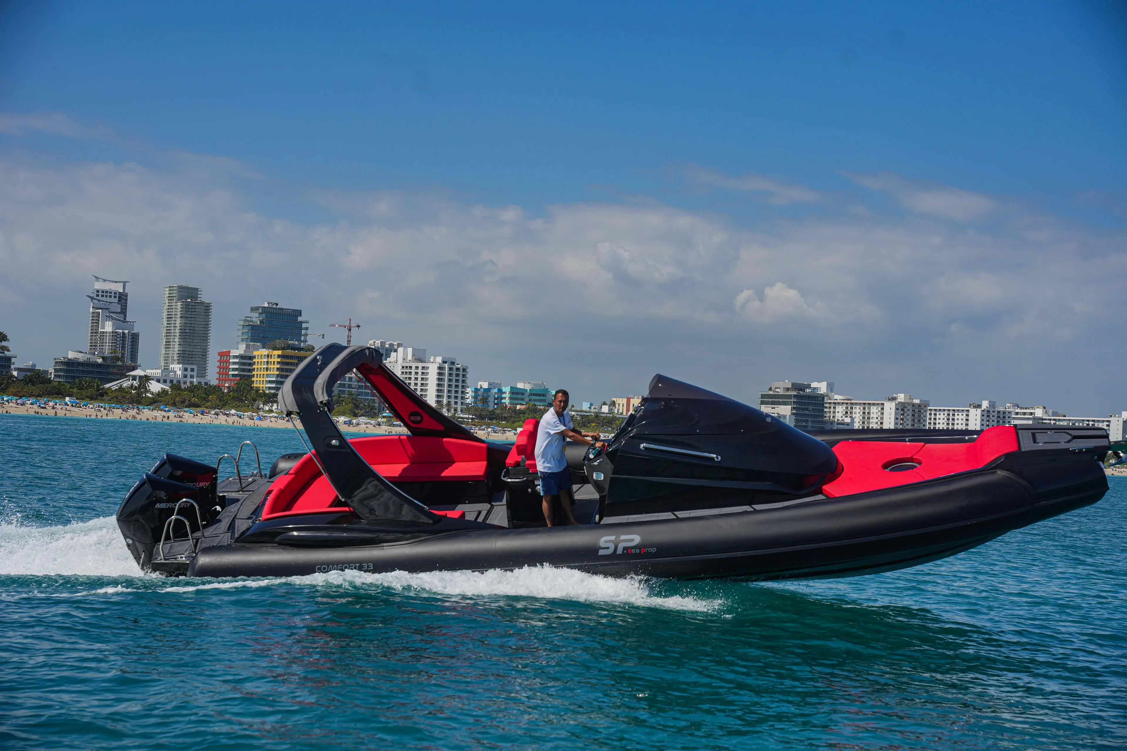 2025 Sea Prop COMFORT 33 speedboat cruising near city skyline.