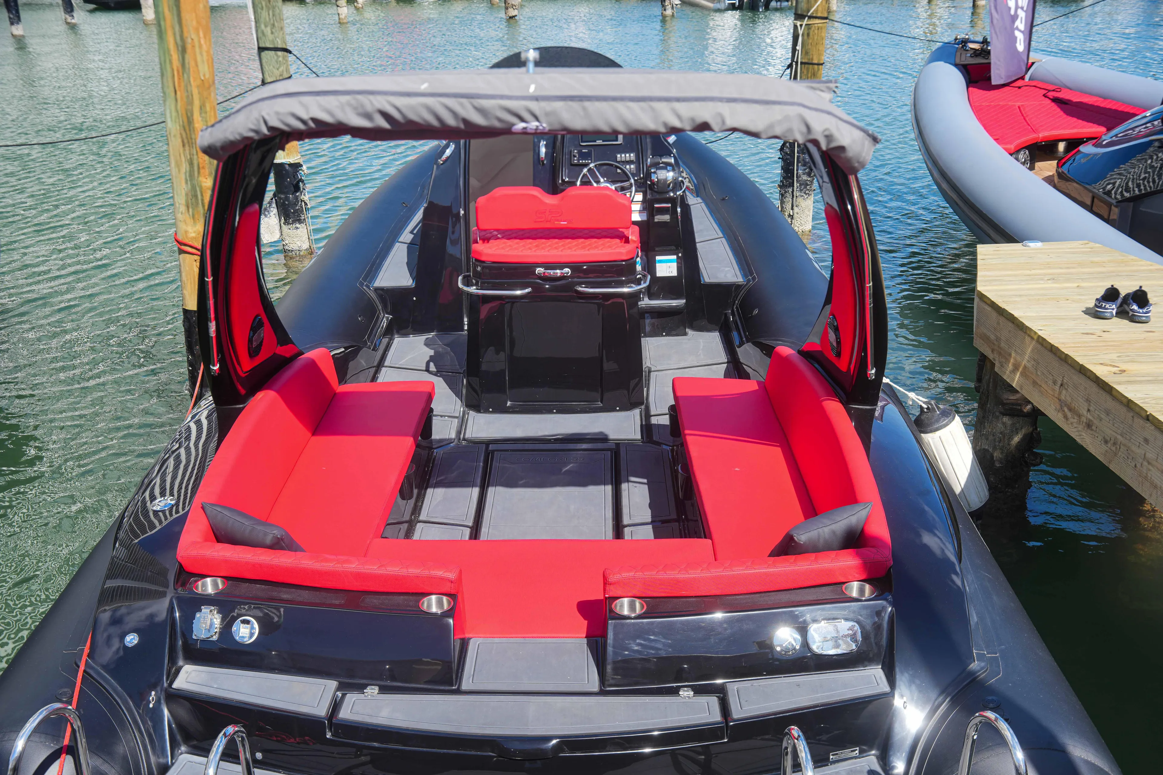 2025 Sea Prop COMFORT 33 boat with red seating and canopy docked at marina.
