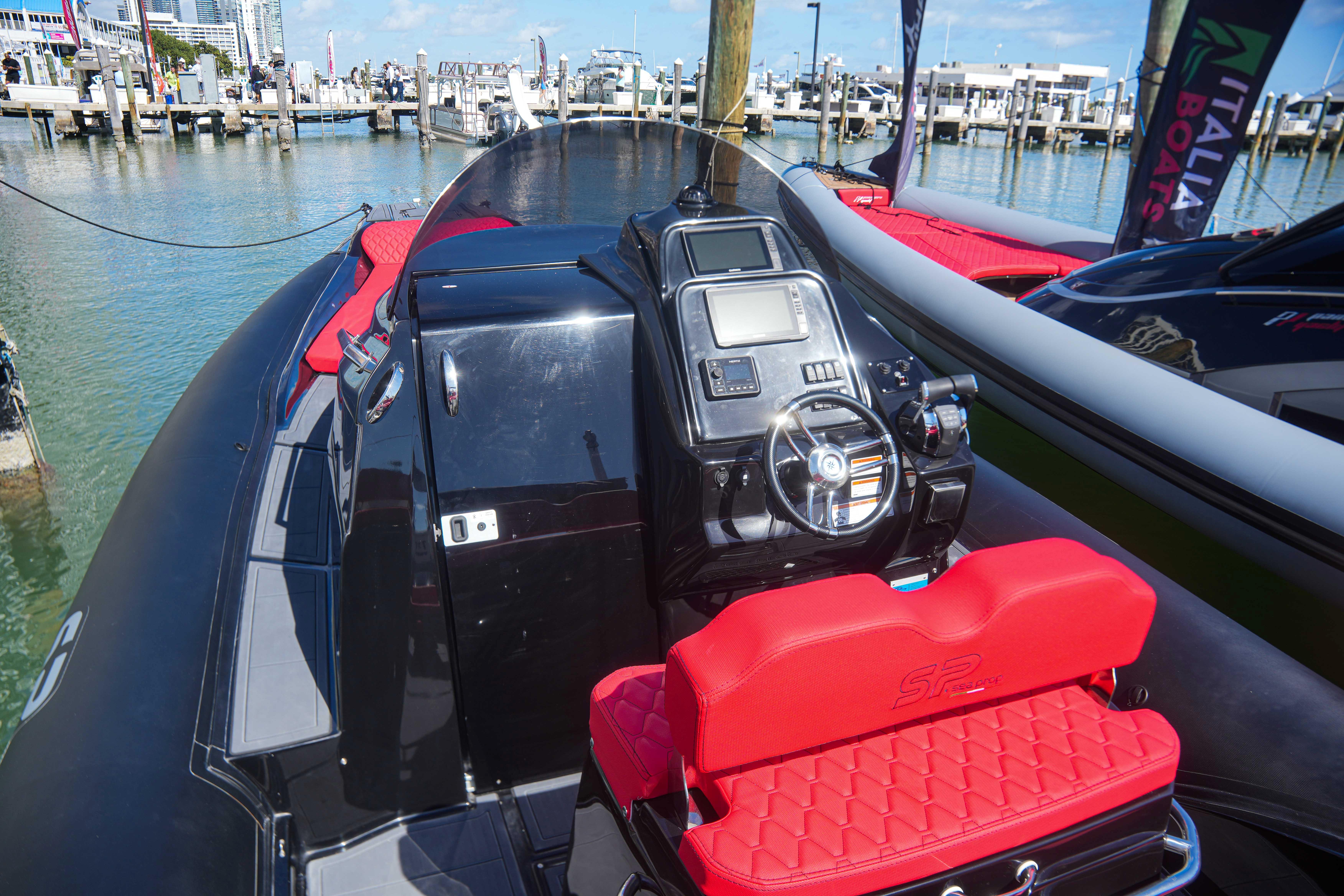 2025 Sea Prop COMFORT 33 boat with red seating at a marina.
