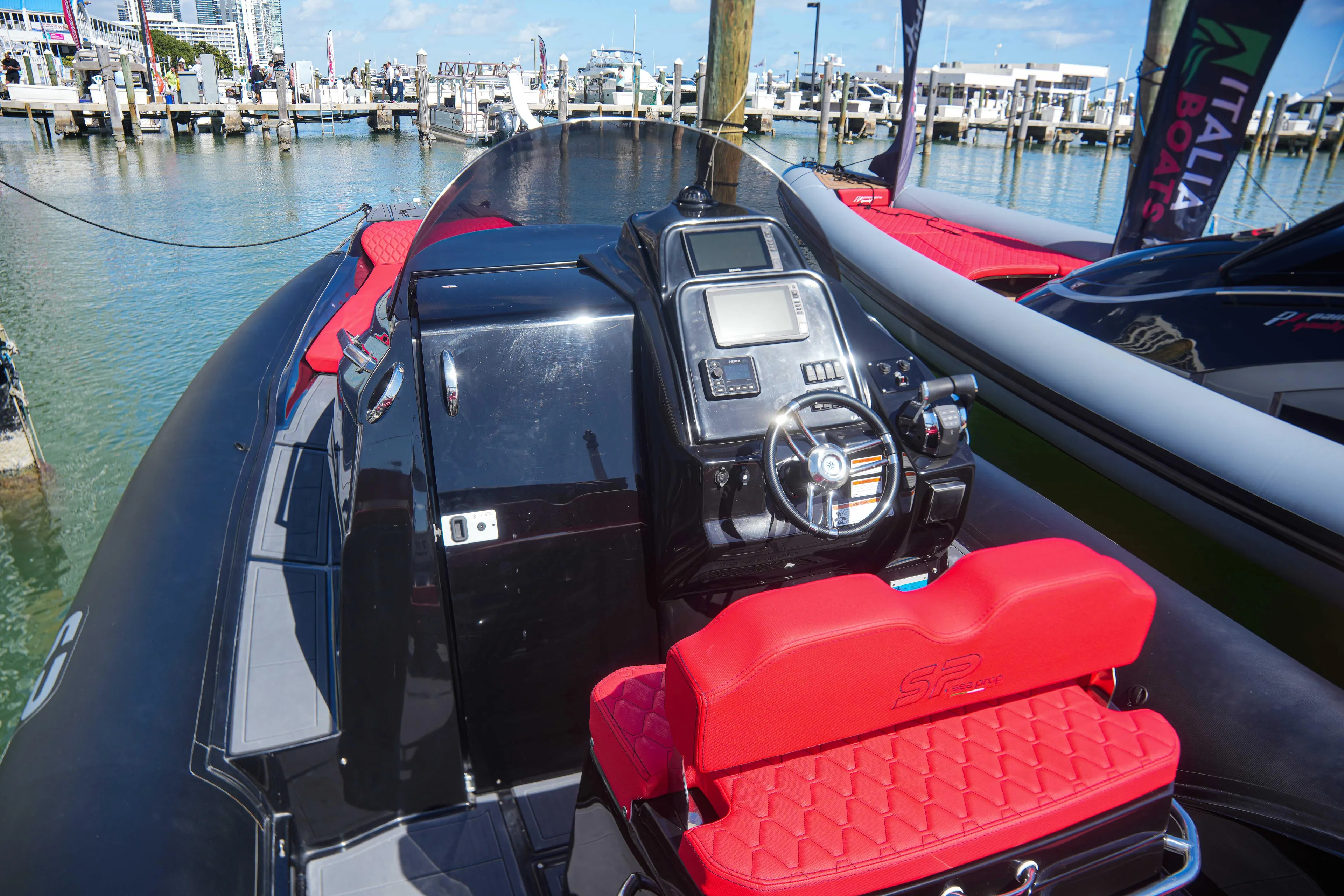 2025 Sea Prop COMFORT 33 boat with red seating at a marina.