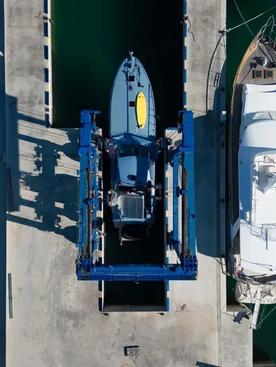 Azaxaki Yacht Photos Pics Aerial view of a 1995 Magnum 50 Bestia yacht in a boat lift at a marina.