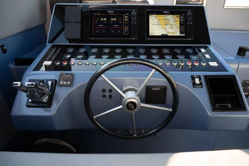 Azaxaki Yacht Photos Pics Control panel of a 1995 Magnum 50 Bestia yacht with steering wheel and navigation screens.