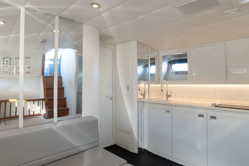 Azaxaki Yacht Photos Pics Luxurious interior of 1995 Magnum 50 Bestia yacht with modern kitchen and seating area.