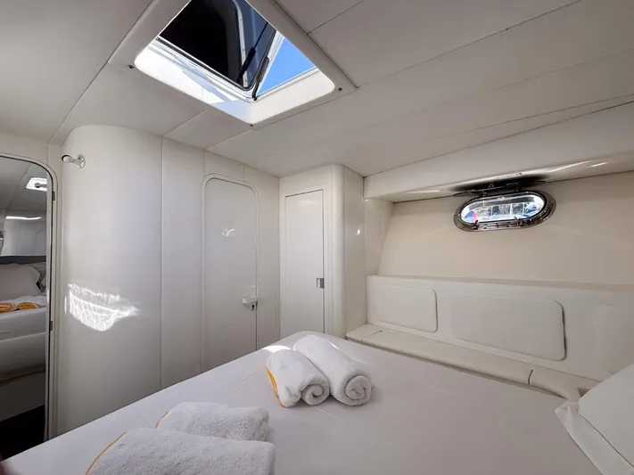 Azaxaki Yacht Photos Pics Luxurious cabin interior of 1995 Magnum 50 Bestia yacht with skylight and porthole.