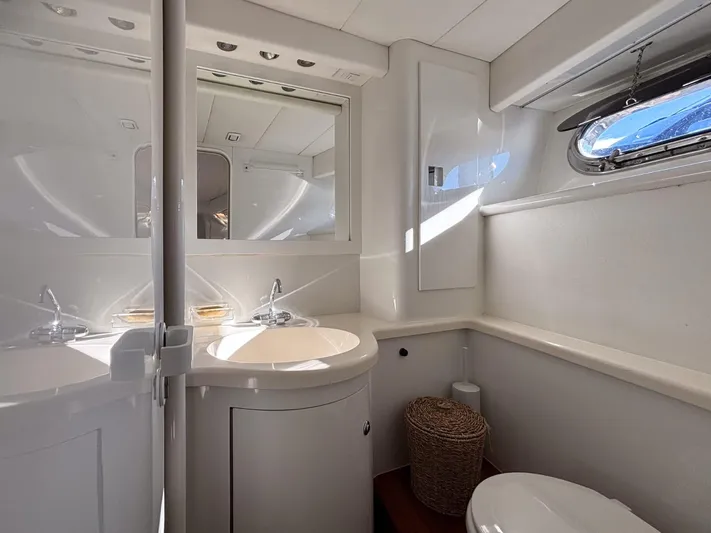 Azaxaki Yacht Photos Pics Luxurious bathroom interior of 1995 Magnum 50 Bestia yacht with modern fixtures and porthole window.