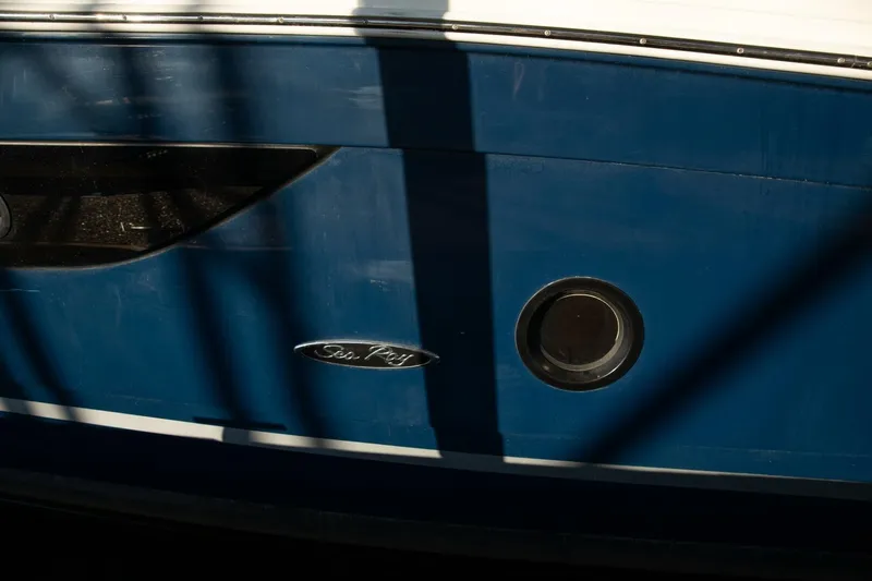  Yacht Photos Pics Close-up of a 2016 Sea Ray 350 Sundancer boat hull with logo and porthole.