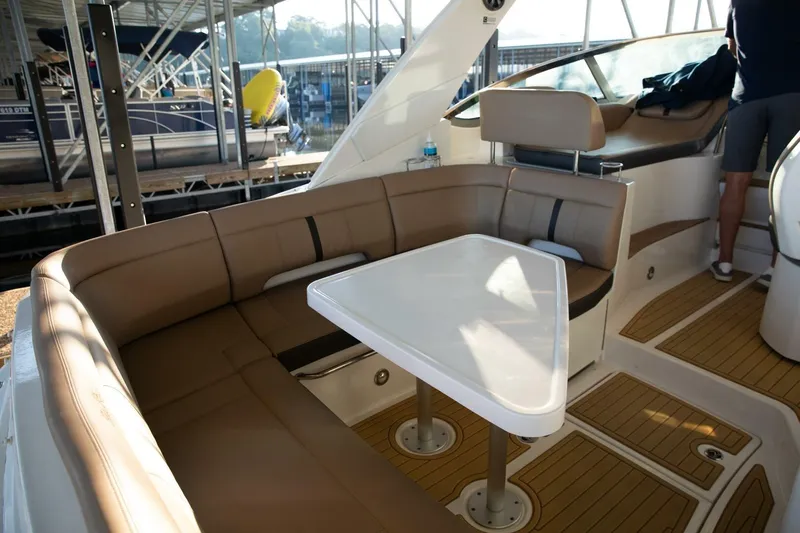  Yacht Photos Pics Interior of 2016 Sea Ray 350 Sundancer with seating and table in a marina setting.
