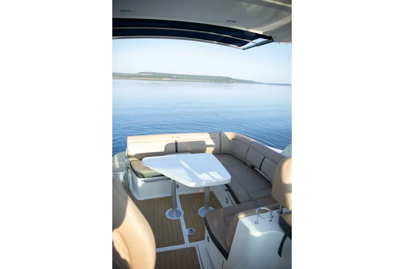  Yacht Photos Pics 2016 Sea Ray 350 Sundancer boat interior with seating and table, overlooking calm water.