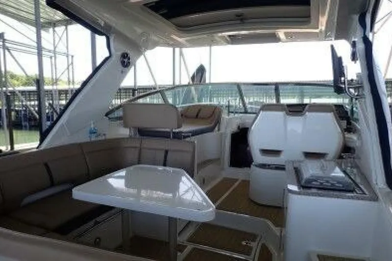  Yacht Photos Pics 2016 Sea Ray 350 Sundancer interior with seating, table, and helm in a marina setting.