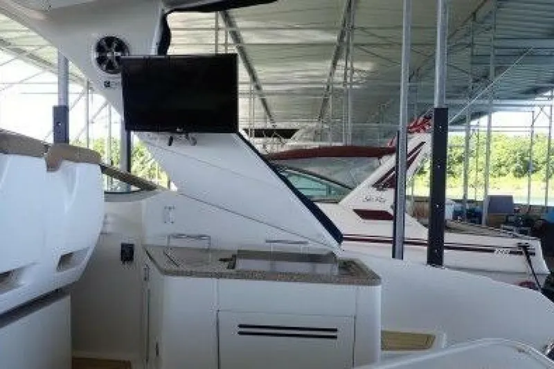  Yacht Photos Pics 2016 Sea Ray 350 Sundancer interior with TV and kitchenette in a covered marina.