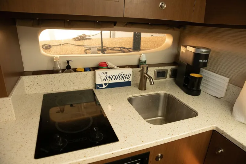  Yacht Photos Pics Kitchen area of 2016 Sea Ray 350 Sundancer with sink, stove, and coffee maker.